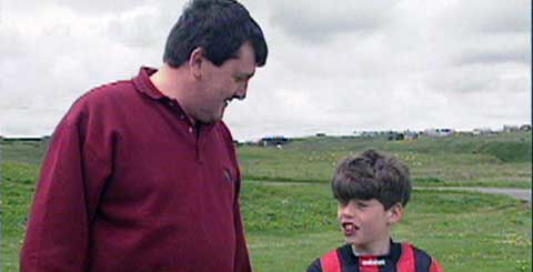 a man and a small boy in a football strip